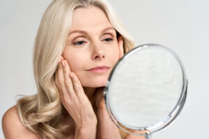 Woman looks in the mirror at her refreshed eye after eyelid surgery in Seattle.