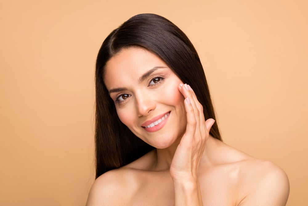 Woman admires her own gorgeous skin after her HydraFacial.